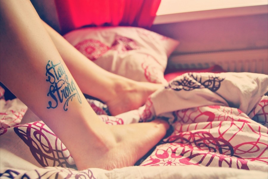 Tatuaje en la pierna de una chica: "Stay Strong" (Mantente fuerte)
