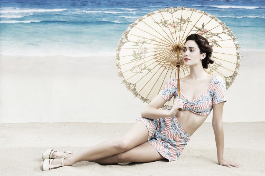 Emmy Rossum sentada en una playa