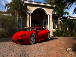 Ferrari rojo frente a una hermosa casa
