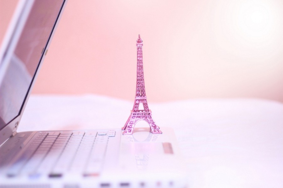 Pequeña Torre Eiffel de color rosa sobre un ordenador portátil