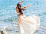 Mujer con vestido blanco frente al mar