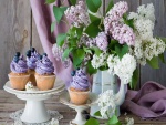 Exquisitos cupcakes junto a un jarrón con lilas