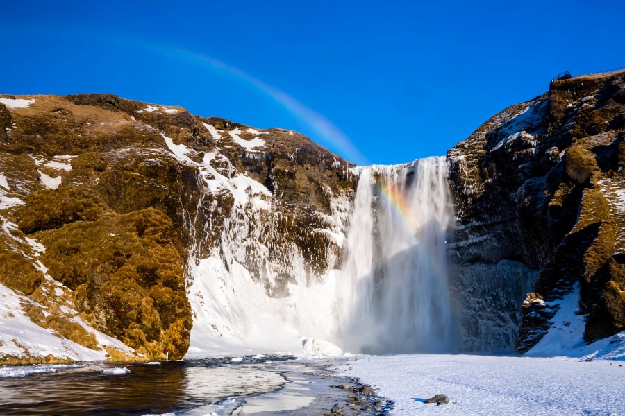 Arcoíris sobre una cascada invernal