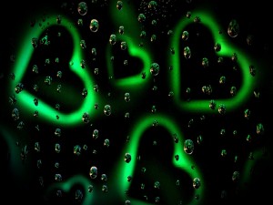 Corazones de neón verde entre gotas de agua