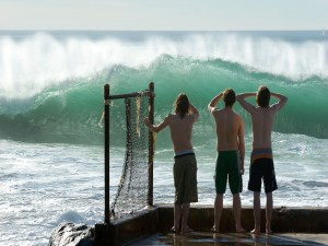 Tres chicos mirando las grandes olas