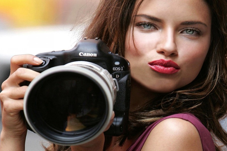 Una hermosa chica con una cámara Canon Eos