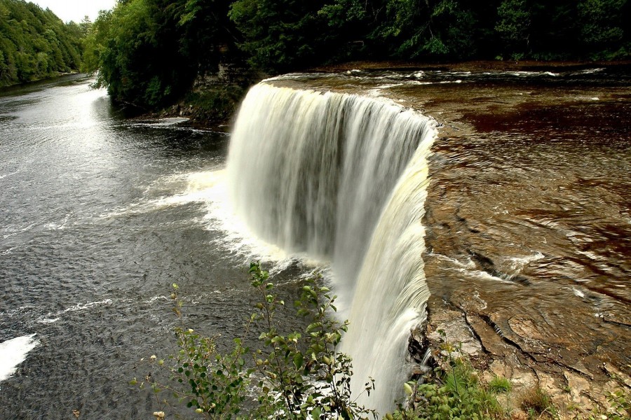 Cristalina agua de la cascada cae en el río