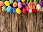 Huevos de Pascua y tulipanes sobre una madera