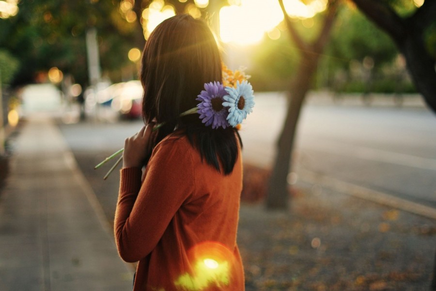 Chica sosteniendo dos flores