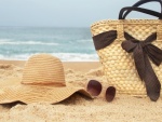 Canasto, sombrero y gafas sobre la arena