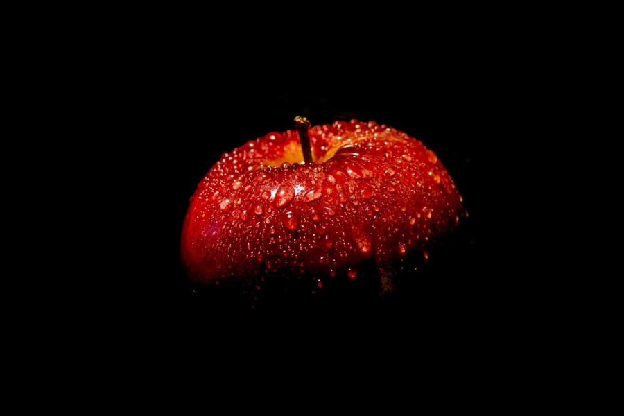 Manzana roja con agua en la oscuridad
