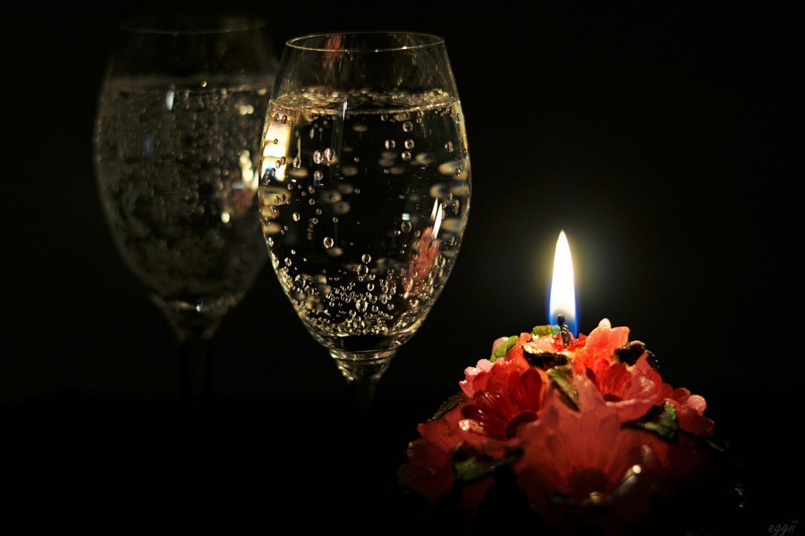 Una copa de champán junto a una vela