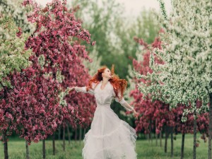 Mujer caminando a través de los árboles florecidos