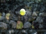 Una pelota de tenis mojada dando giros