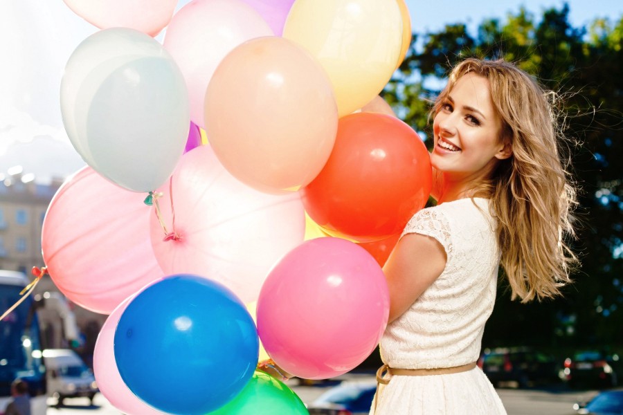 Mujer divirtiéndose con unos coloridos globos