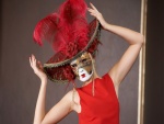 Mujer con máscara, sombrero y plumas de color rojo
