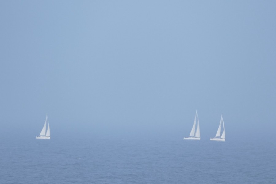 Barcos de vela en el  mar en un día de niebla