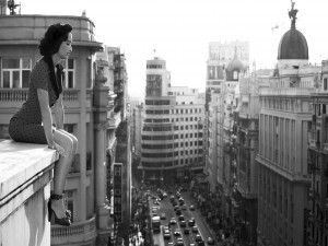 Mujer sentada en el borde de un edificio