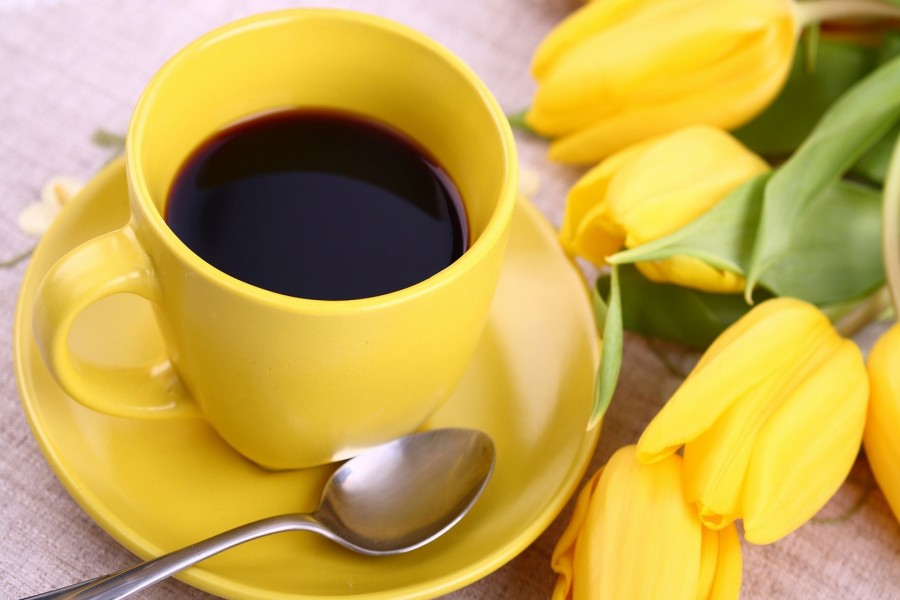 Taza con café y tulipanes amarillos