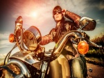 Chica con chaqueta de cuero y gafas de sol sentada en una moto
