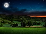 Campo bajo la luna llena y un cielo estrellado