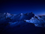 Montañas cubiertas de nieve bajo el cielo nocturno