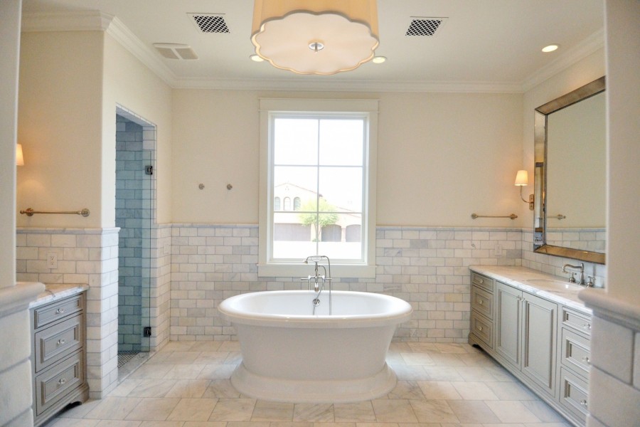 Amplio cuarto de baño de mármol con una bañera en el medio