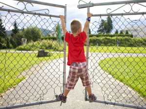Niño jugando en un portón