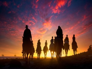 Jinetes a caballo en la puesta del sol